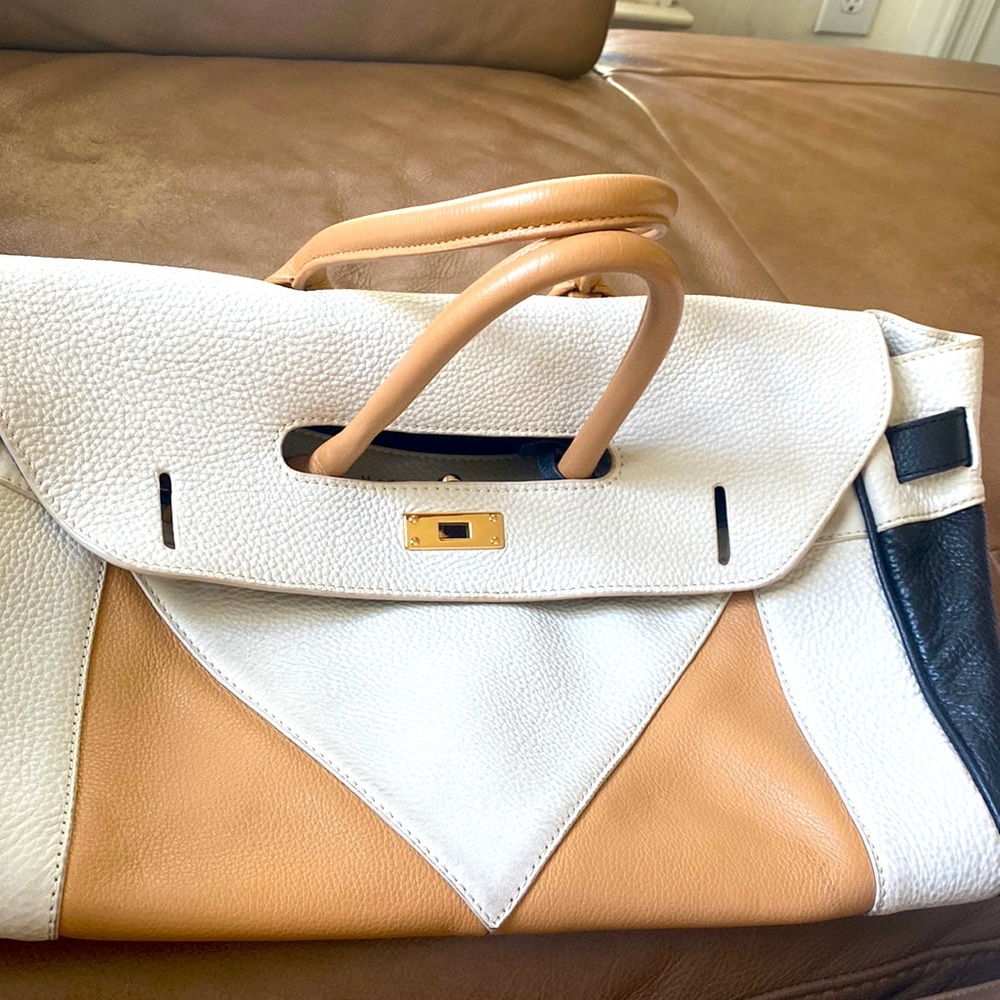 A cream colored beautiful large bag great for travel